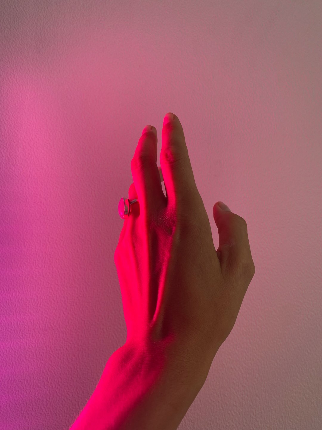 Manos iluminadas con luz rosa